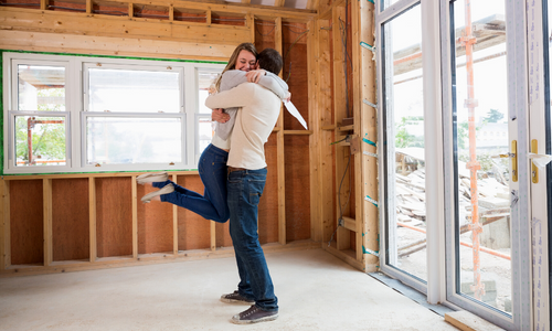 Couple hugging in newly built house